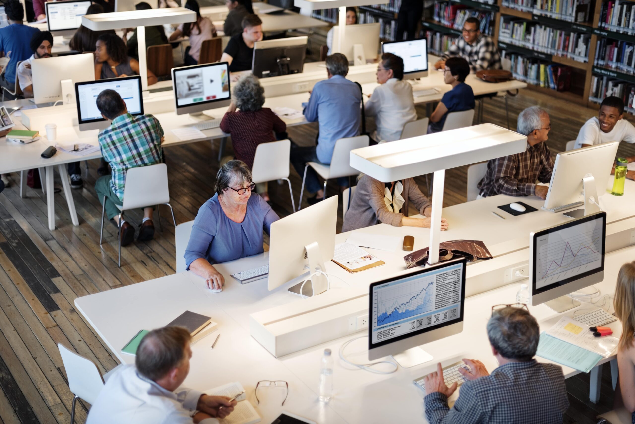 Diverse individuals collaborating in a modern library for software development research and outsourcing insights.